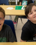 Two smiling boys in a classroom