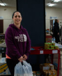 A woman, Corinne, stops for a smile while visiting the St. Mary of the Bay Food Pantry in Warren, Rhode Island.