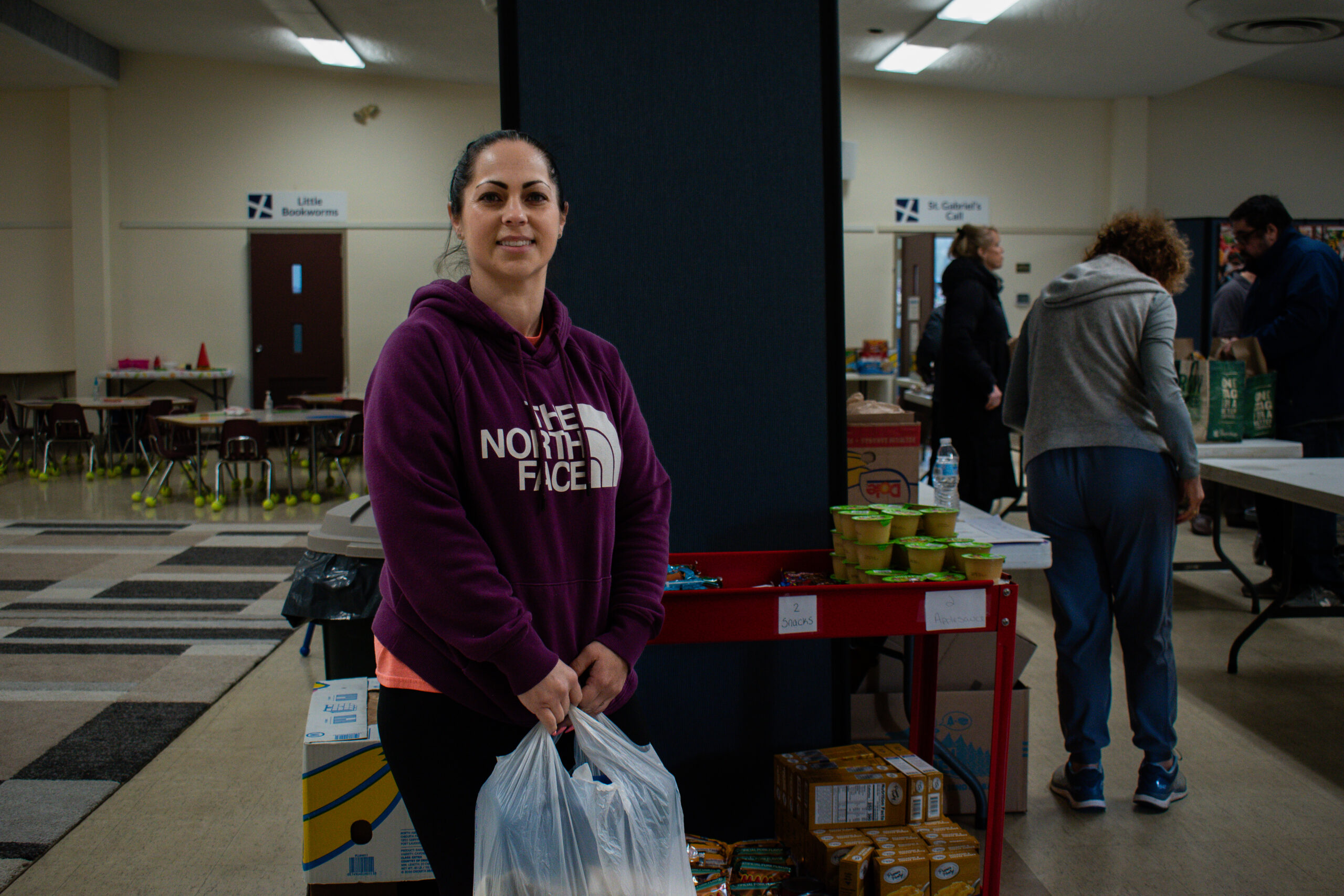 A woman, Corinne, stops for a smile while visiting the St. Mary of the Bay Food Pantry in Warren, Rhode Island.